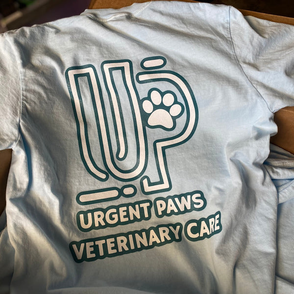 Urgent Paws Veterinary Care logo in dark green ink on a light blue tee at RVA Threads screen printing, Virginia