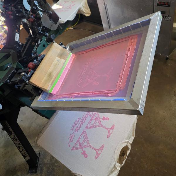 Waterman Spirits Bottoms Up screen flooded with pink ink, raised over a printed Ivory Comfort Colors tee at RVA Threads screen printing, Virginia